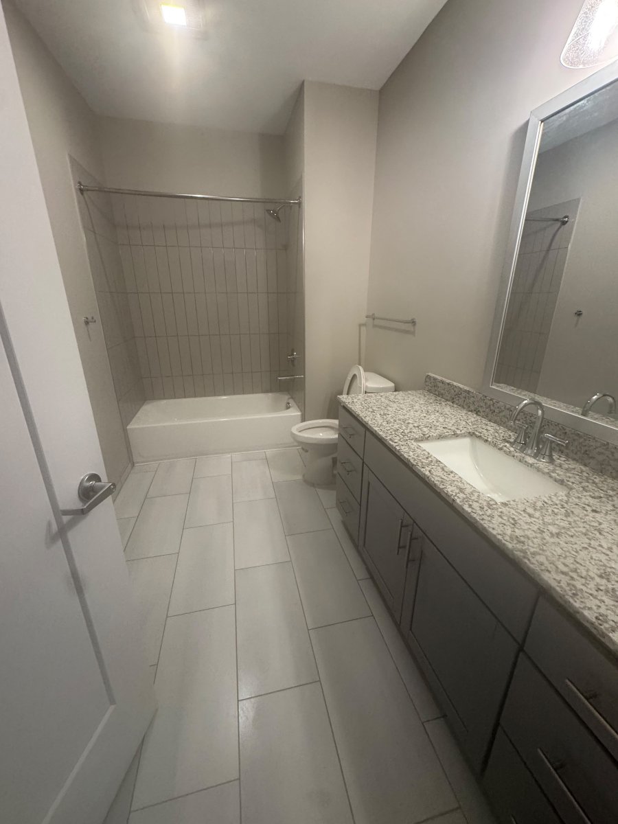 Bathroom with granite vanity, tiled floor and tub, ready for move-in