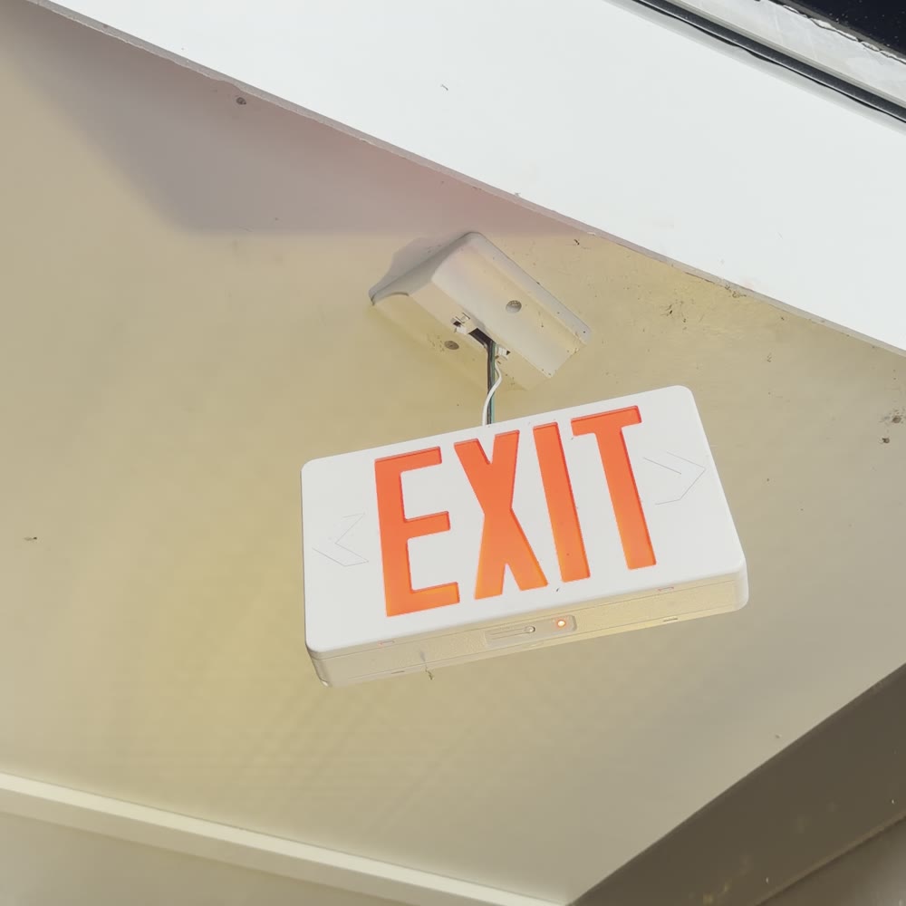 Exit sign dangling by its wires below its ceiling mount