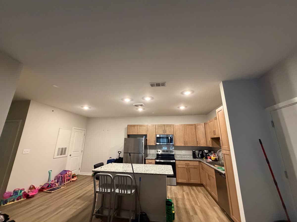 Open kitchen and dining area with a clean ceiling and recessed lights