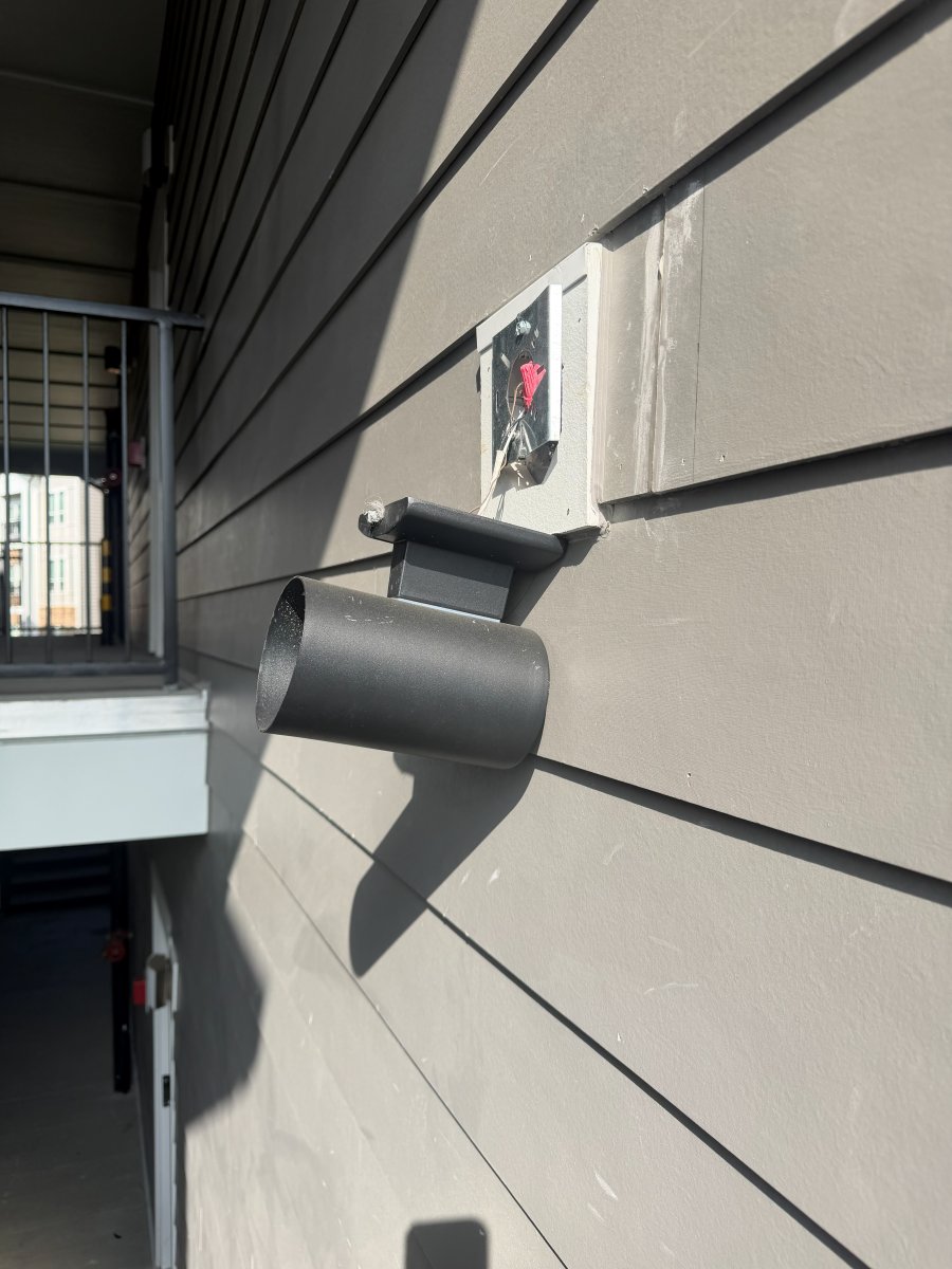 Exterior wall light hanging loose below its mounting box on the siding