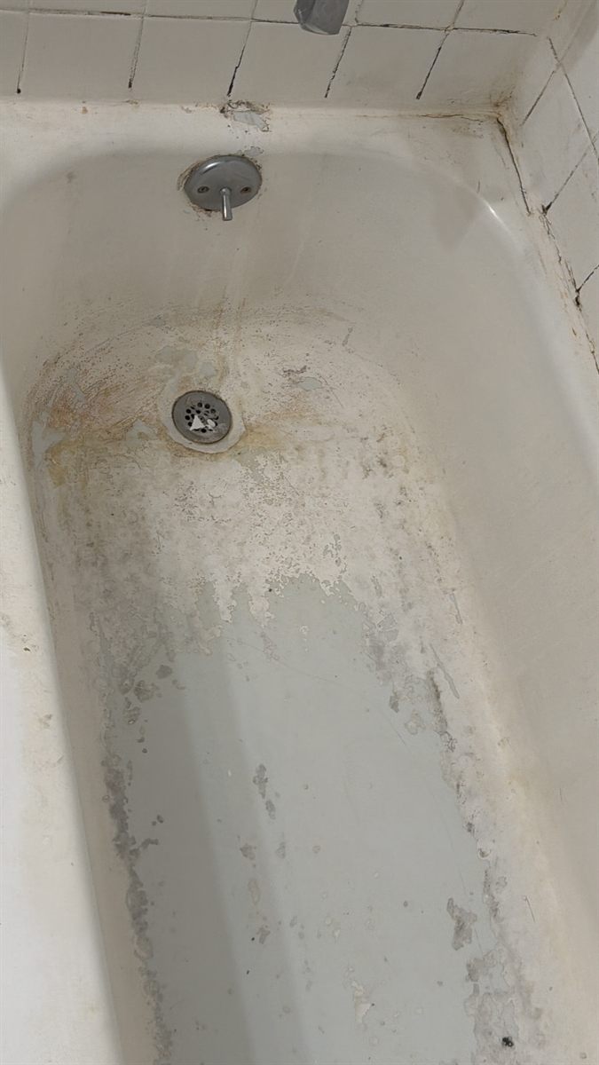 Bathtub basin heavily stained and scaled before refinishing